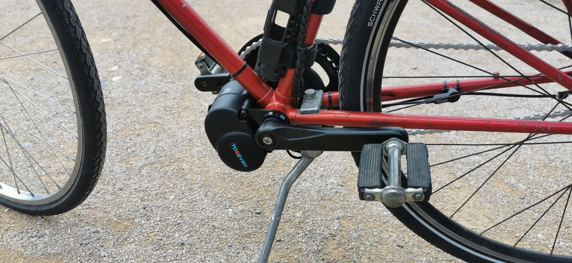 Moteur de pédalier Toseven monté sur un vélo rouge