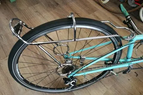 Porte-bagage chromé monté sur un vélo turquoise