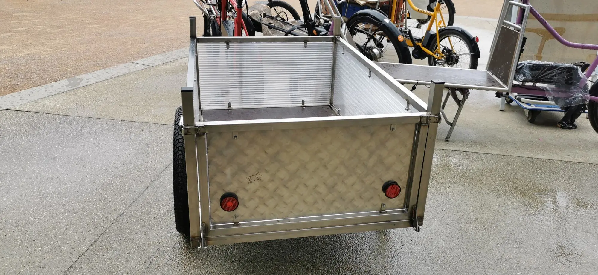 Arrière de la remorque avec sa paroi en aluminium strié et ses catadioptres rouges
