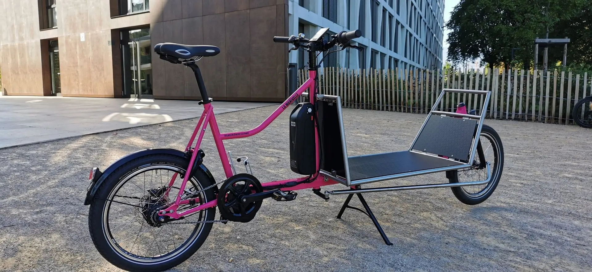 Vélo cargo rose avec batterie et plateau