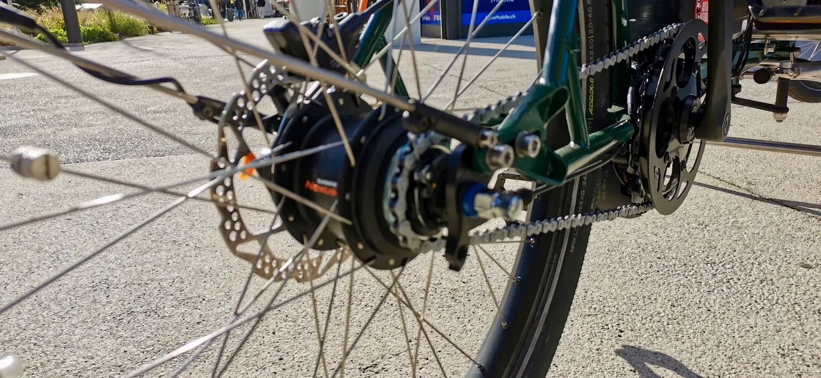 Détail du moyeu Shimano Nexus, du frein à disque et de la chaîne sur un cadre vert