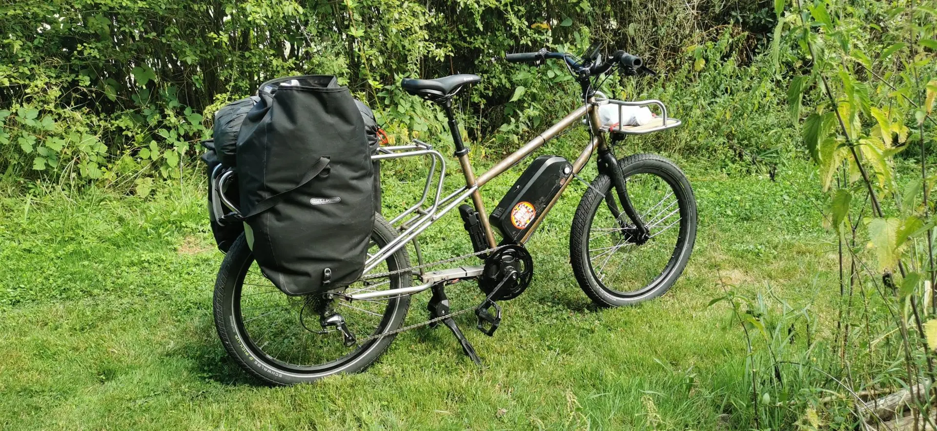 Le longtail chargé de sacoches de voyage, posé dans l’herbe