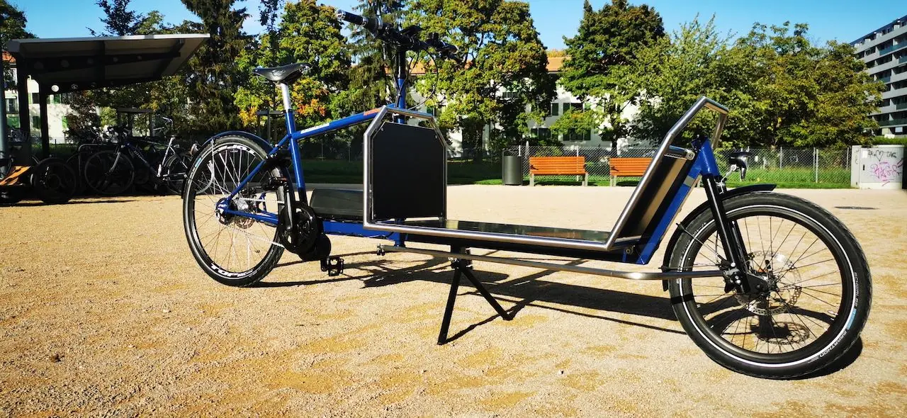 L’aventurier bleu avec sa grande plateforme, garé dans un parc