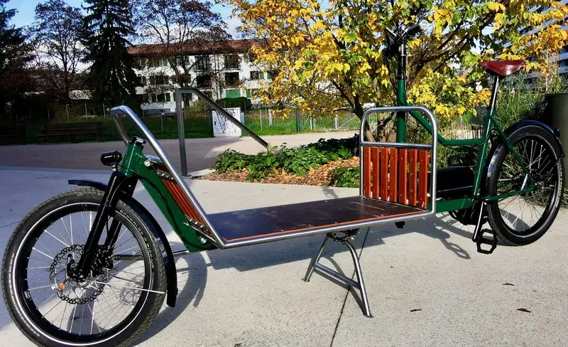 L’aventurier, vélo cargo vert avec grande plateforme de chargement à l’avant