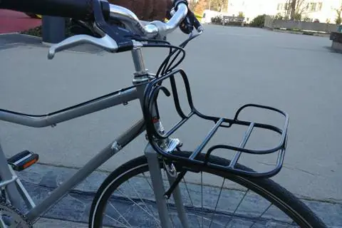 Porte-bagage avant noir monté sur un vélo de ville gris