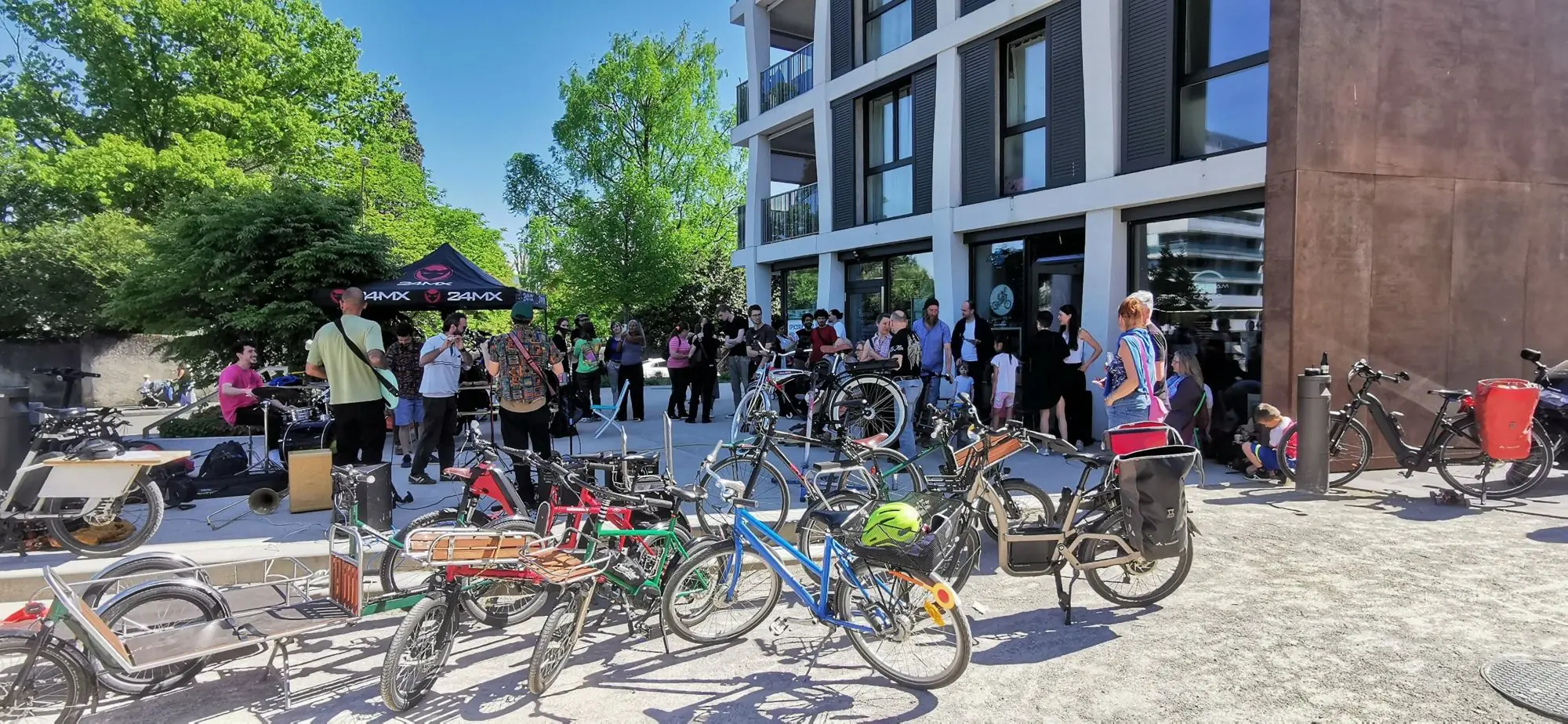 Vélos cargo et public réunis devant l’atelier pendant un concert en plein air