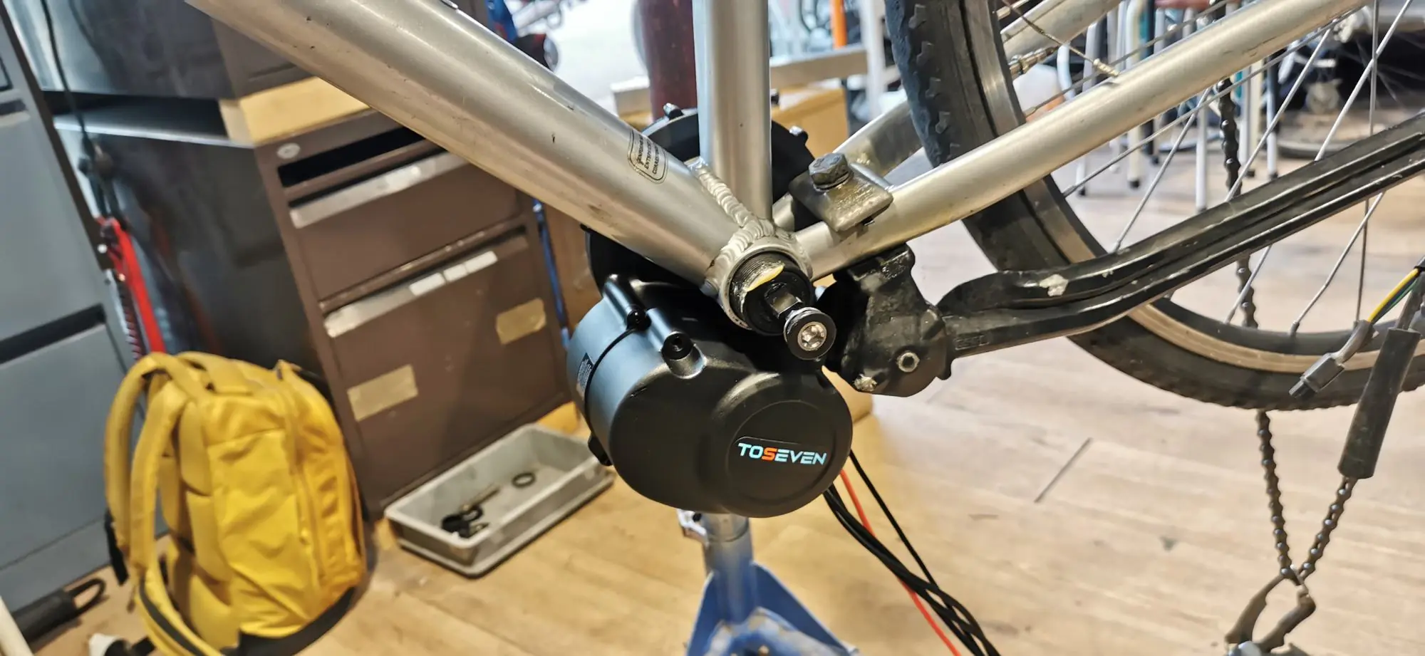 Moteur Toseven en place sur le boîtier de pédalier d’un cadre, dans l’atelier